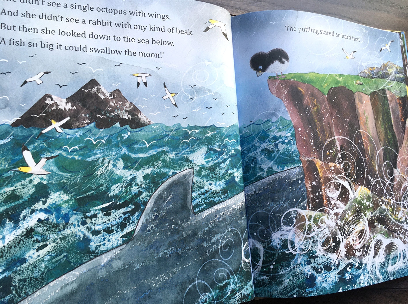 Puffling and the Stormy Sea scene where Puffling on a cliff stares down at a big fish in the sea